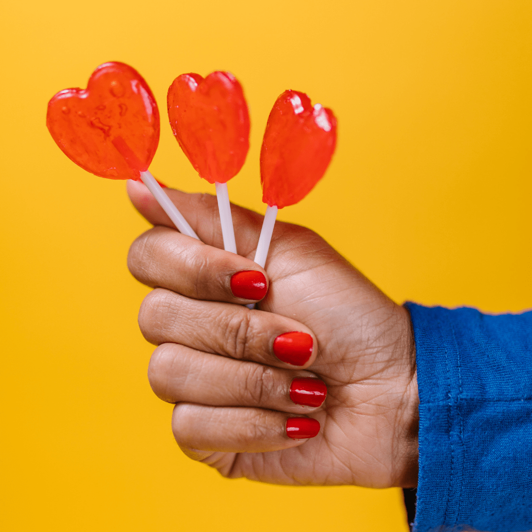 Woman Holding Red Heart Lollies