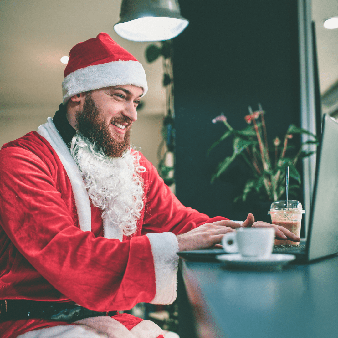 Man Dressed As Santa On His Laptop